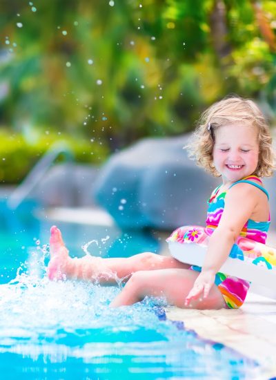 Little girl playing in a warm pool
